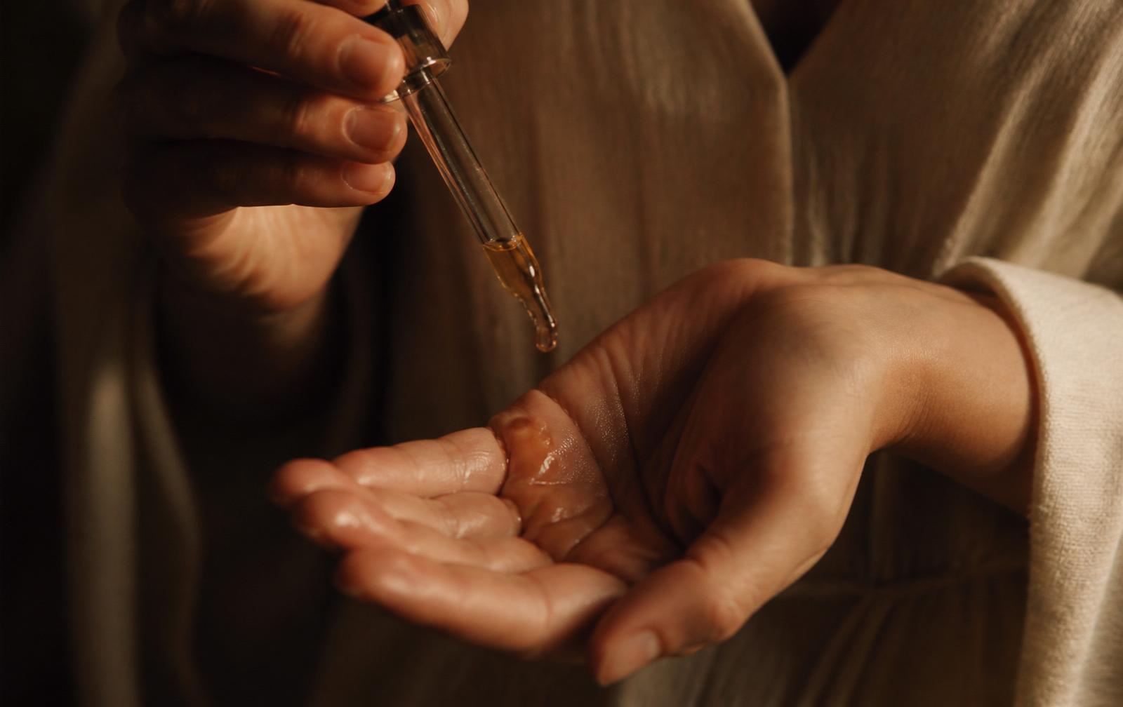 Golden oil dropped into a warm open palm