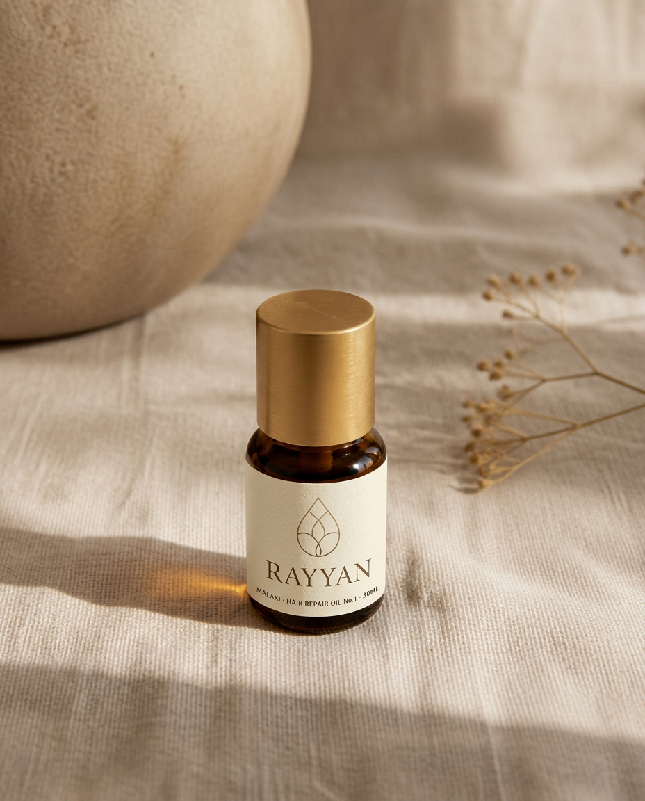 Small amber glass oil bottle with gold cap on linen
